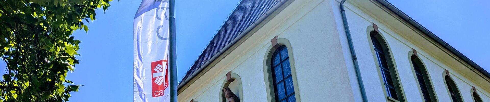 Unser Gebäude mit Caritas Fahne davor